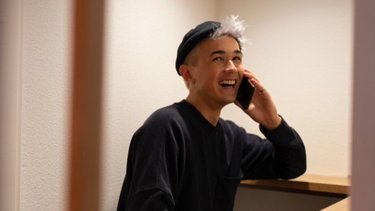 young man laughing with smartphone